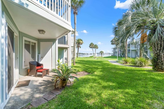 view of yard with a balcony and a water view