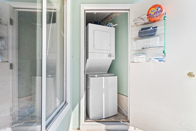 clothes washing area featuring stacked washer / dryer