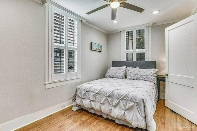 bedroom with crown molding, ceiling fan, and light hardwood / wood-style floors