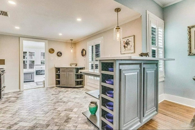 kitchen featuring pendant lighting, ornamental molding, and plenty of natural light