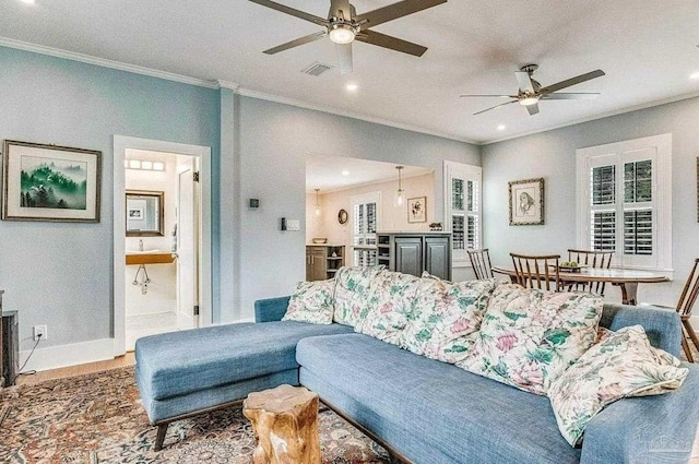 living room with crown molding, ceiling fan, and hardwood / wood-style flooring