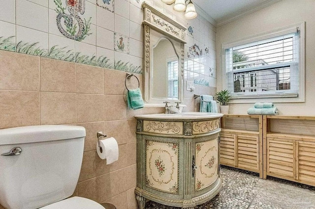 bathroom featuring crown molding, toilet, and tile walls