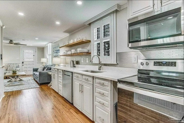 kitchen with crown molding, stainless steel appliances, sink, and backsplash