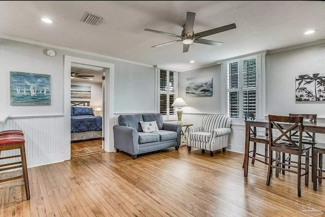 living room with crown molding, hardwood / wood-style floors, and ceiling fan