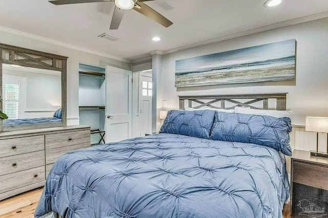 bedroom with ceiling fan, ornamental molding, and wood-type flooring