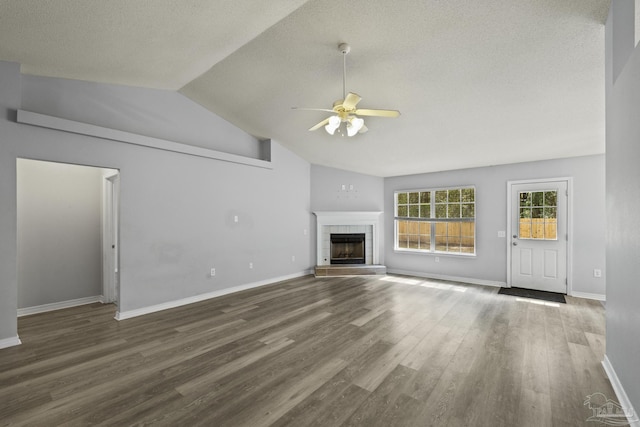 unfurnished living room with a fireplace, lofted ceiling, a ceiling fan, wood finished floors, and baseboards