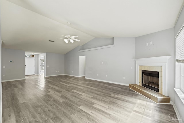 unfurnished living room with visible vents, ceiling fan, wood finished floors, vaulted ceiling, and a fireplace