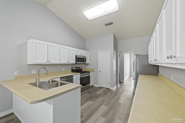 kitchen featuring visible vents, stainless steel appliances, light countertops, light wood-style floors, and a sink