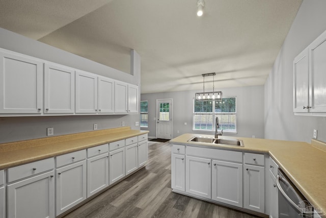 kitchen with dark wood-type flooring, a sink, white cabinetry, light countertops, and dishwasher