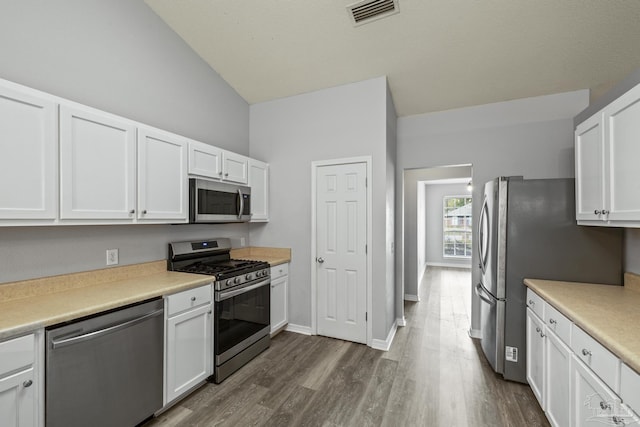 kitchen with visible vents, white cabinets, dark wood-style floors, stainless steel appliances, and light countertops