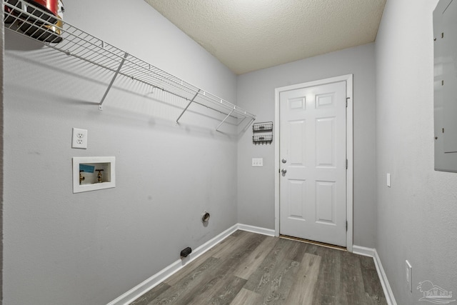 washroom featuring laundry area, a textured ceiling, baseboards, and wood finished floors