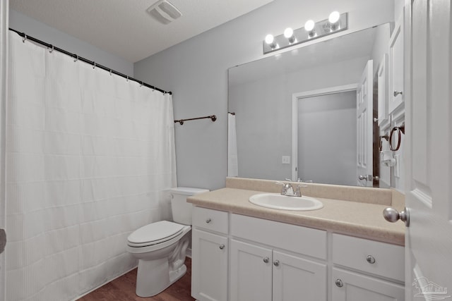 full bath with visible vents, toilet, wood finished floors, a textured ceiling, and vanity