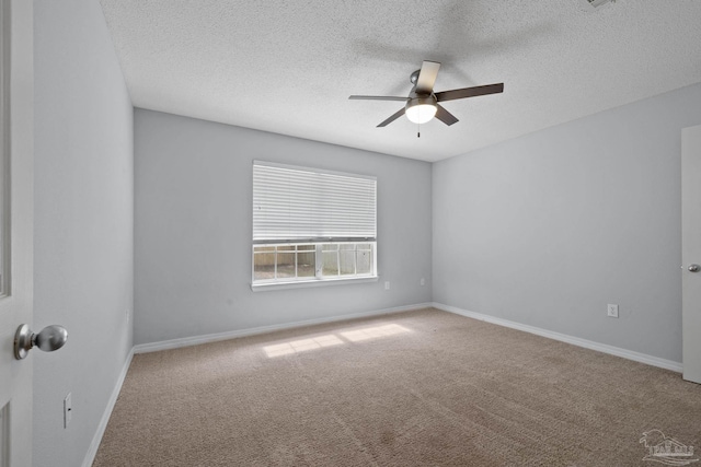 carpeted spare room with ceiling fan, a textured ceiling, and baseboards