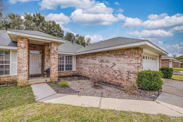 single story home with a garage, brick siding, and roof with shingles