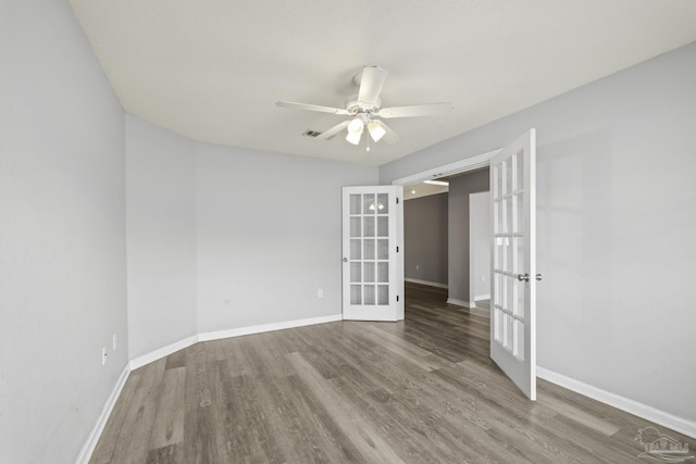 spare room with french doors, ceiling fan, baseboards, and wood finished floors