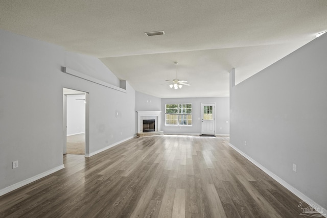 unfurnished living room featuring lofted ceiling, a fireplace, wood finished floors, a ceiling fan, and baseboards