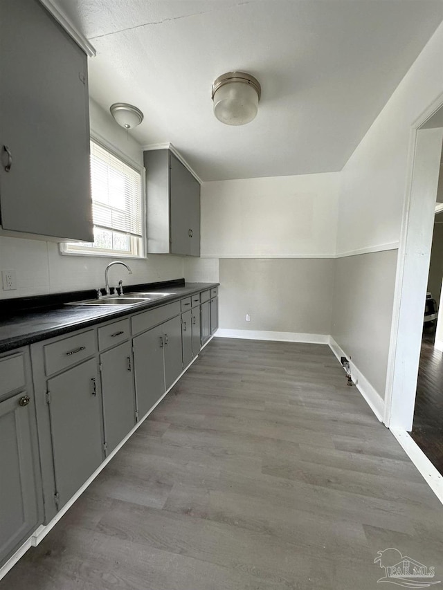 kitchen with sink, hardwood / wood-style flooring, and gray cabinets