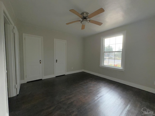 unfurnished bedroom featuring dark hardwood / wood-style floors and ceiling fan