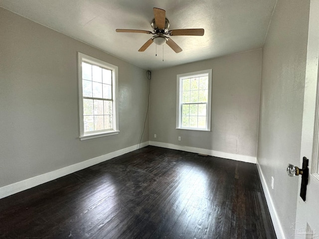 spare room featuring dark wood-type flooring and ceiling fan