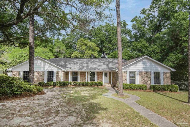 ranch-style home with covered porch, a front lawn, and brick siding