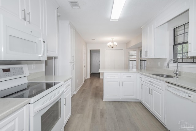 kitchen featuring a sink, white cabinets, visible vents, white appliances, and a chandelier