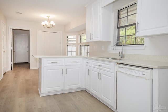 kitchen featuring a peninsula, a sink, a notable chandelier, visible vents, and dishwasher