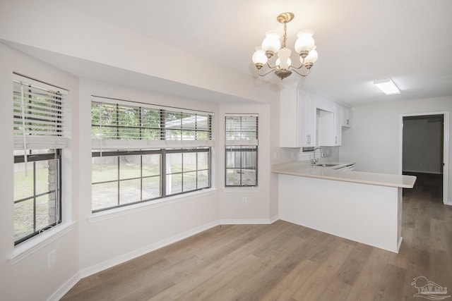 kitchen featuring light wood-style floors, plenty of natural light, a chandelier, and a sink
