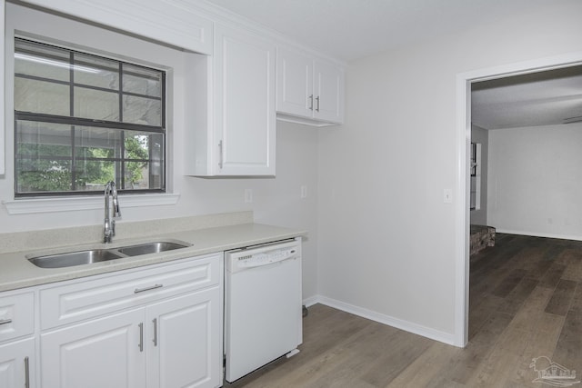 kitchen with a sink, wood finished floors, light countertops, and dishwasher