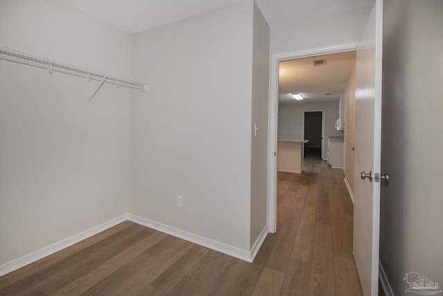 spacious closet with dark wood-style floors