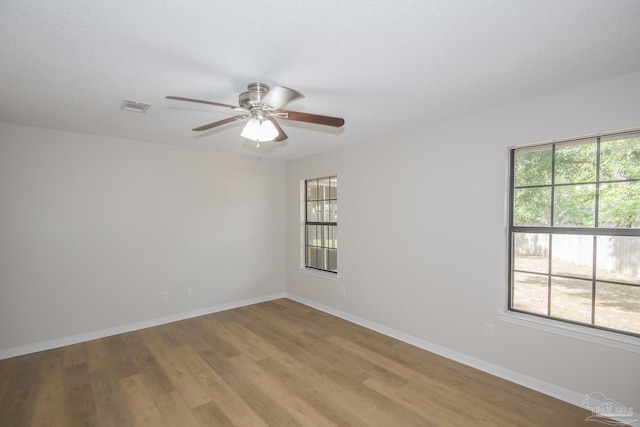 spare room with ceiling fan, baseboards, visible vents, and light wood-style floors