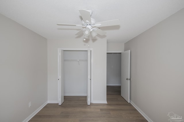 unfurnished bedroom with a closet, wood finished floors, baseboards, and ceiling fan