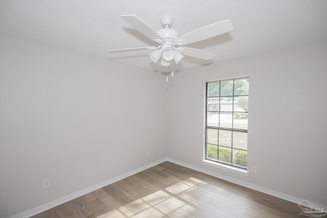 empty room with wood finished floors, baseboards, and ceiling fan
