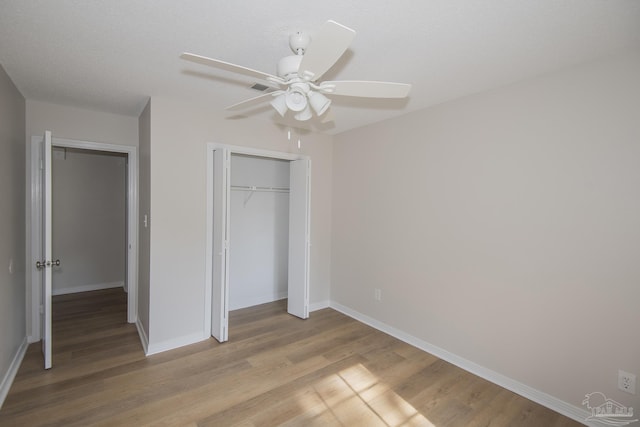 unfurnished bedroom with a closet, visible vents, light wood finished floors, ceiling fan, and baseboards
