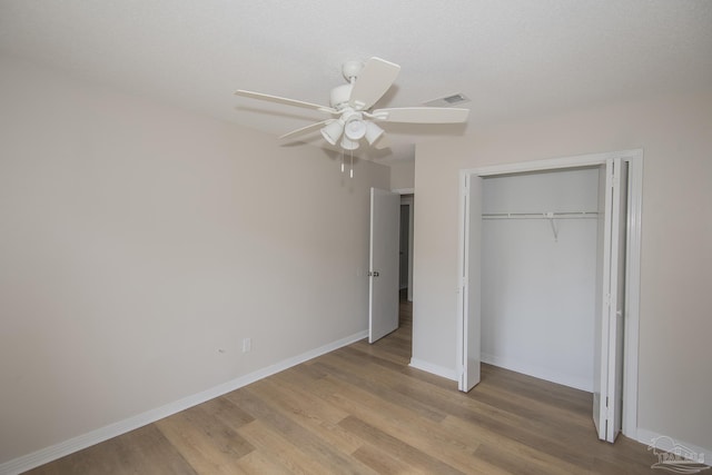unfurnished bedroom with light wood-style flooring, a closet, visible vents, baseboards, and ceiling fan