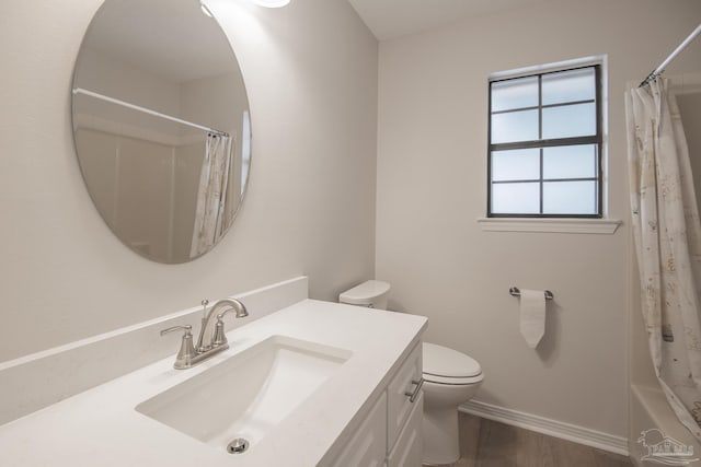 bathroom featuring baseboards, vanity, toilet, and wood finished floors