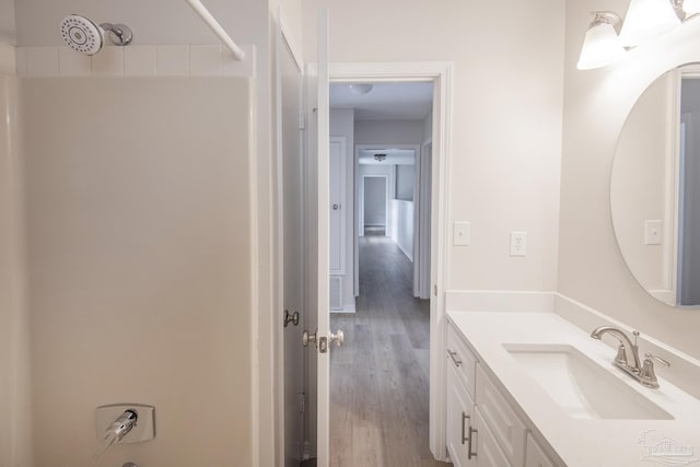 full bath featuring a shower, wood finished floors, and vanity