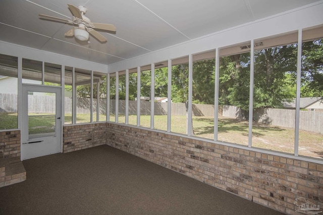 unfurnished sunroom featuring a healthy amount of sunlight and ceiling fan