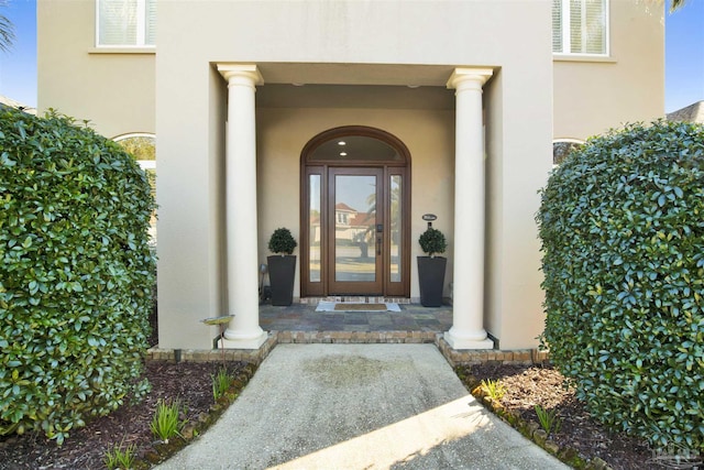 property entrance with visible vents and stucco siding