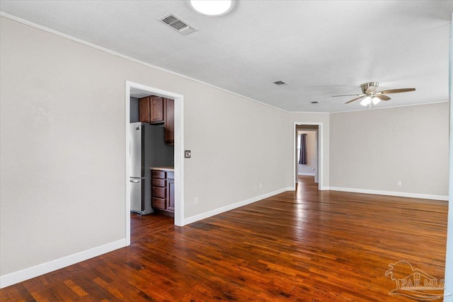 empty room featuring crown molding, dark hardwood / wood-style floors, and ceiling fan