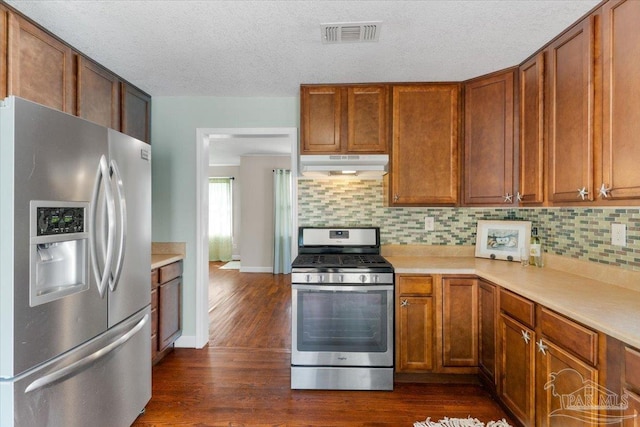 kitchen featuring stainless steel appliances, dark hardwood / wood-style flooring, decorative backsplash, and a textured ceiling