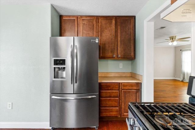 kitchen with ceiling fan, appliances with stainless steel finishes, dark hardwood / wood-style floors, and a textured ceiling