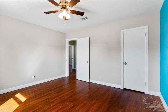 unfurnished bedroom featuring ceiling fan and dark hardwood / wood-style flooring