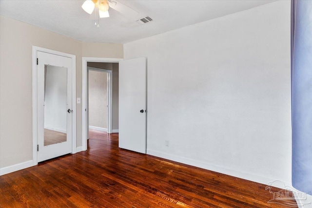 spare room with dark wood-type flooring and ceiling fan