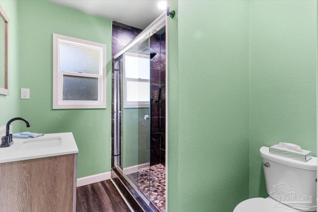 bathroom featuring vanity, hardwood / wood-style floors, an enclosed shower, and toilet