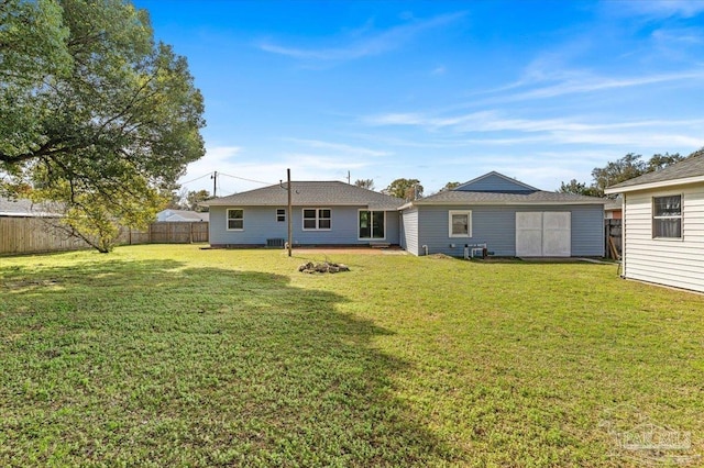 back of property featuring a lawn and a storage unit