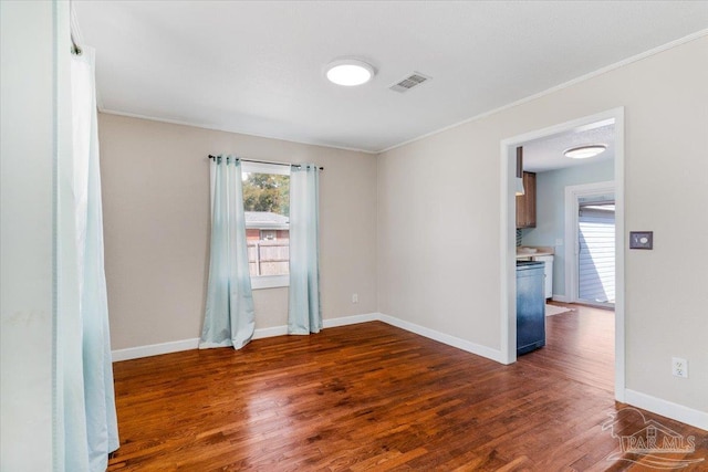 spare room featuring crown molding and dark hardwood / wood-style floors