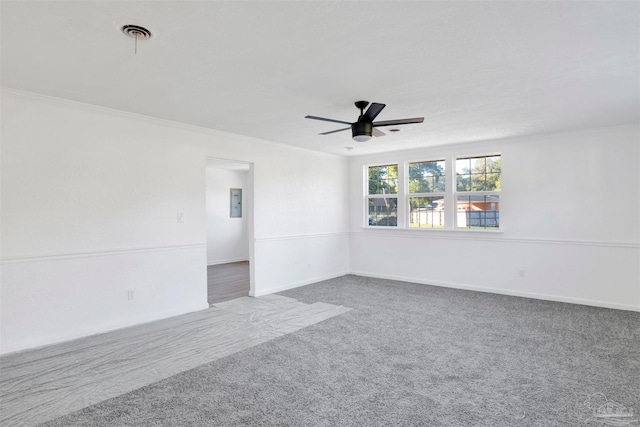 unfurnished room featuring ceiling fan, carpet floors, and crown molding