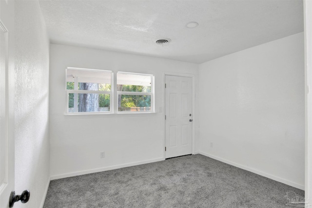 carpeted empty room with a textured ceiling