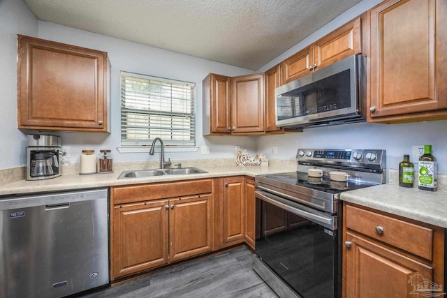 2000 Silverado Rd, Pensacola, FL 32506 - kitchen featuring appliances with stainless steel finishes, a sink, dark wood-style flooring, a textured ceiling, and light countertops