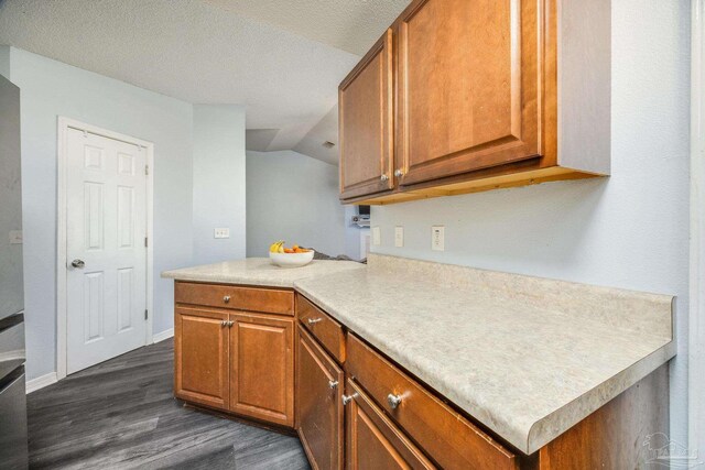 2000 Silverado Rd, Pensacola, FL 32506 - kitchen featuring dark wood-style flooring, brown cabinetry, light countertops, a peninsula, and vaulted ceiling